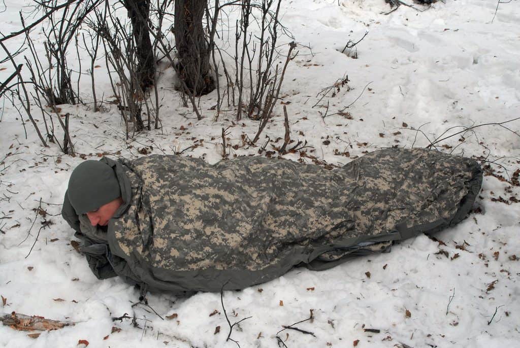 Camper sleeping in a bivy in winter